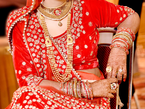 Pakistani Indian bridal showing her wedding Gold necklace in wedding