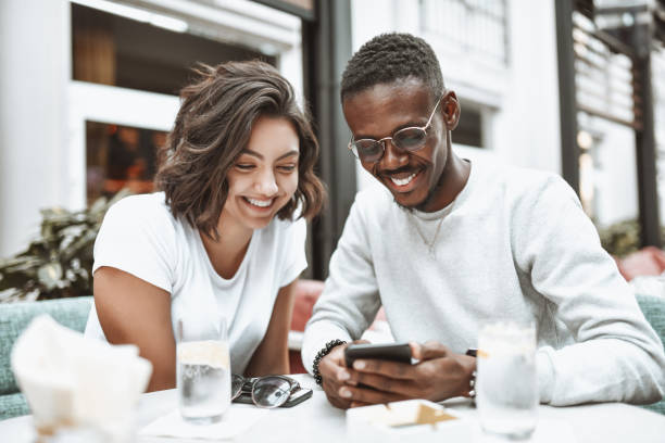 istock Smiling Multiethnic Couple Exploring Online Coffee Bar Menu While Dating 1307748663