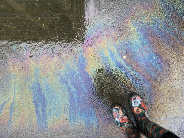 istock Colourful rain boots on next to oil spill on asphalt 1307750671