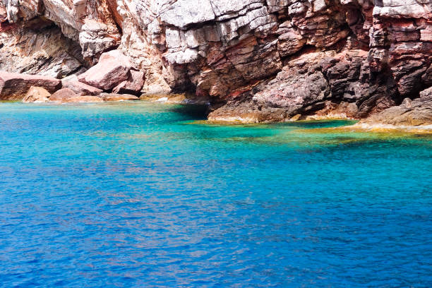 istock Metamorphic rock. Rocky seashore, view from water, summer landscape 1307753616
