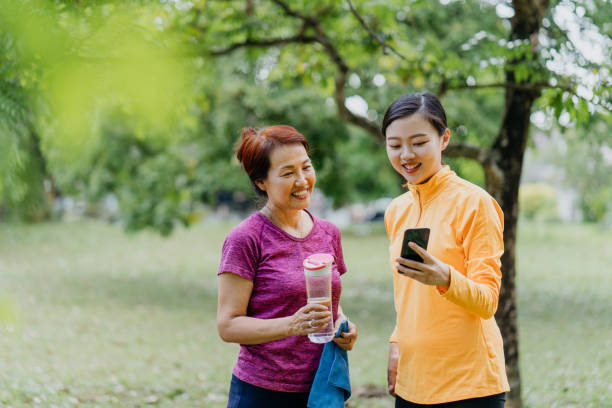 istock Asian Chinese mother and daughter using phone having a break after exercising 1307753784