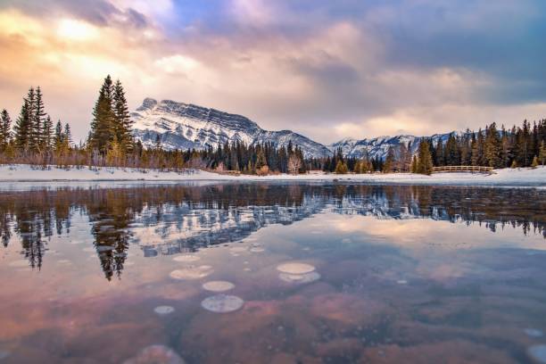 istock Sunrise Reflecting Into A Frozen Cascade Ponds 1307753937