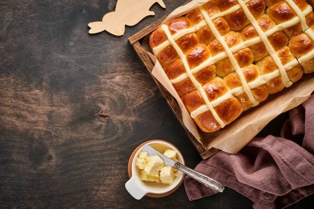 istock Easter Hot Cross Buns. Traditional breakfast and Easter baking holiday decorations rabbiton dark old wooden background. Bright colors, view from above on wooden table 1307753957