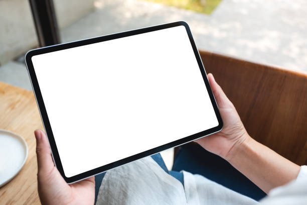 istock a woman holding digital tablet with blank white desktop screen in cafe 1307754093