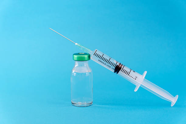 istock Potential trials stage concept on blue background. Close up Vials with sterile needle syringe. Research and Development, Vaccination 1307754758