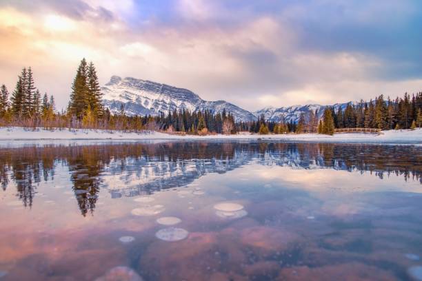istock Sunrise Reflecting Into A Frozen Cascade Ponds 1307754960