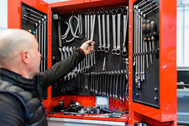 istock Mechanic in a car repair shop picking up work tools 1307755927
