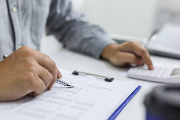 istock Businessman analyzing investment charts and pressing calculator buttons over documents. Accounting Concept. 1307759952