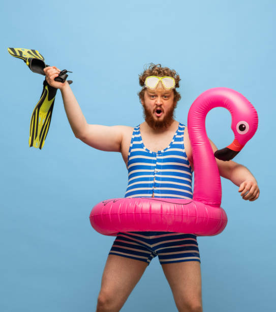 istock Funny red-headed man in swimming suit isolated on blue background. 1307760072