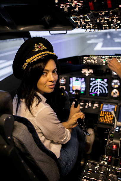 пилот-женщина капитан самолета готовится к взлетам в кабине самолета. - cockpit pilot night airplane стоковые фото и изображения