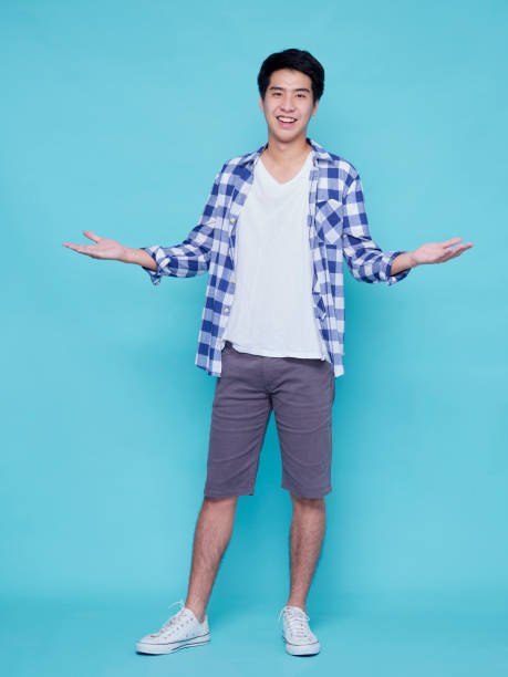 istock Asian handsome man presenting on blue background 1307761625