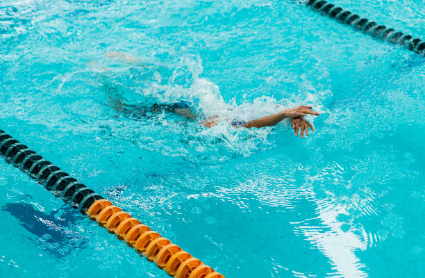 istock Young athletic man with butterfly swimming technique 1307763675