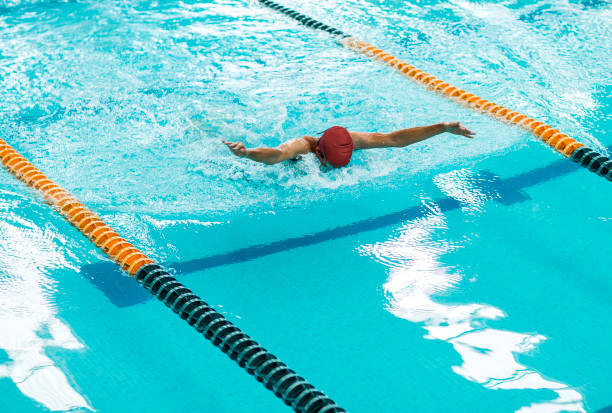 istock Young athletic man with butterfly swimming technique 1307763679