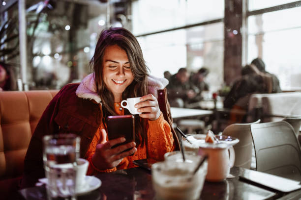 weibliche genießen kaffeezeit und mit smartphone im restaurant - espresso men coffee shop drinking stock-fotos und bilder