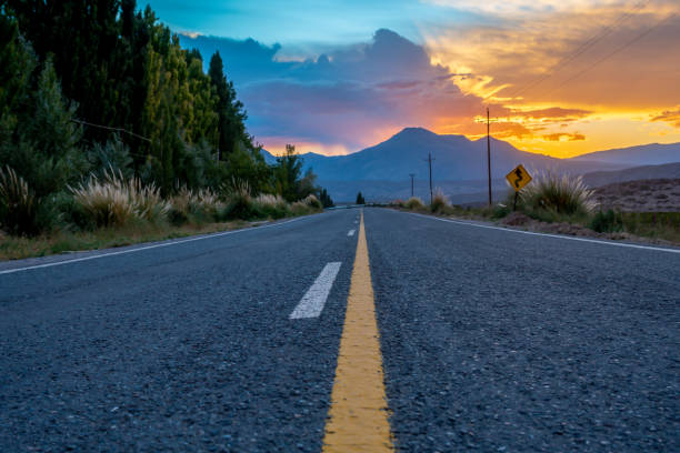 istock winding road sign at sunset en route 1307764649