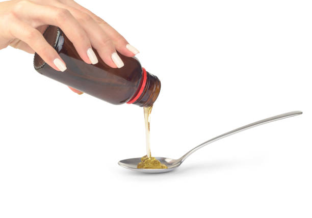 istock l bottle in hand pouring in syrup spoon isolated 1307765913