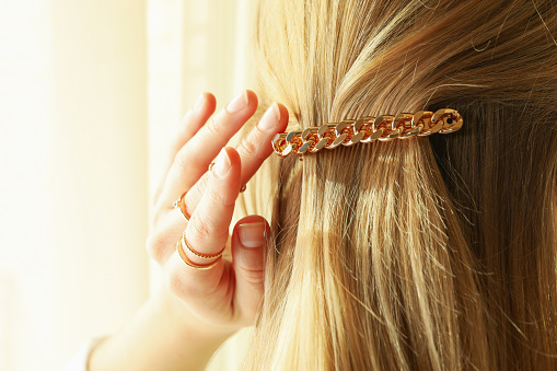 Woman with beautiful hair clip and jewelries, close up