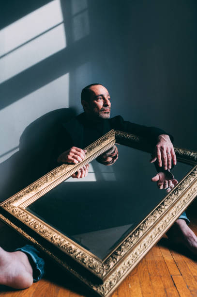 istock Man holding a big antique mirror 1307767859