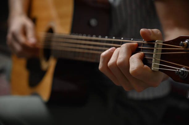istock Man playing acoustic guitar, cover for online courses, learning at home. 1307767860