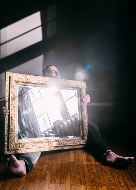 Man sitting behind a big antique mirror