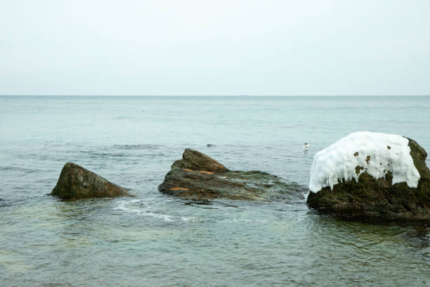Winter sea shore with clear water and big stones