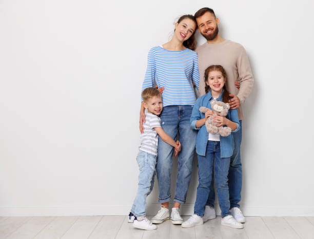 istock Happy parents with kids standing in empty room 1307768347