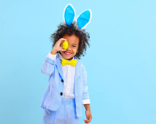istock Funny little black child covering eye with Easter egg and smiling 1307768569