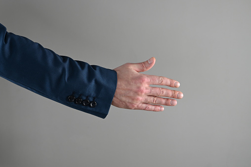 a man in a suit stretches out his hand . High quality photo