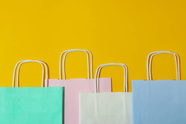 istock Blank colorful paper bags on yellow background 1307769902