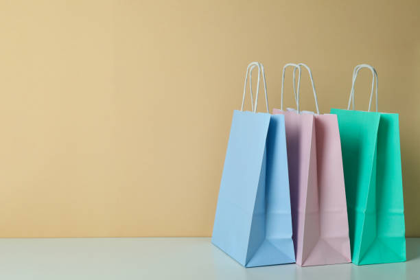 istock Blank paper bags against beige background, space for text 1307769933