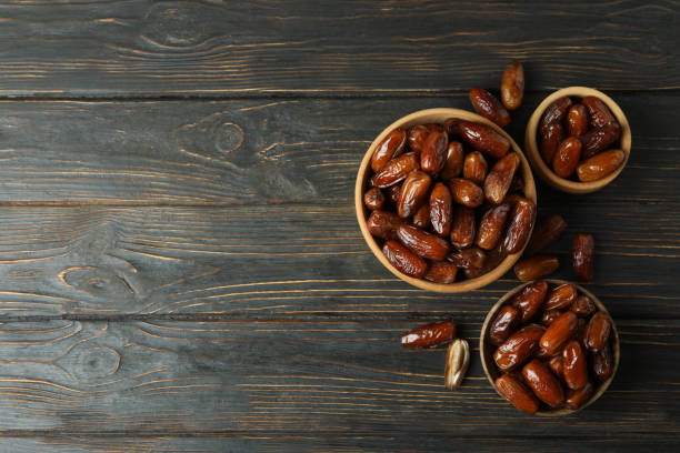 istock Bowl with dried dates on wooden table 1307770186