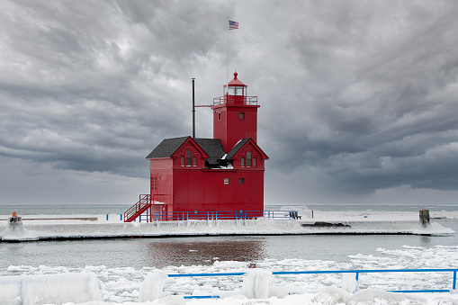 Red Michigan lighthouse in winter with stormy sky