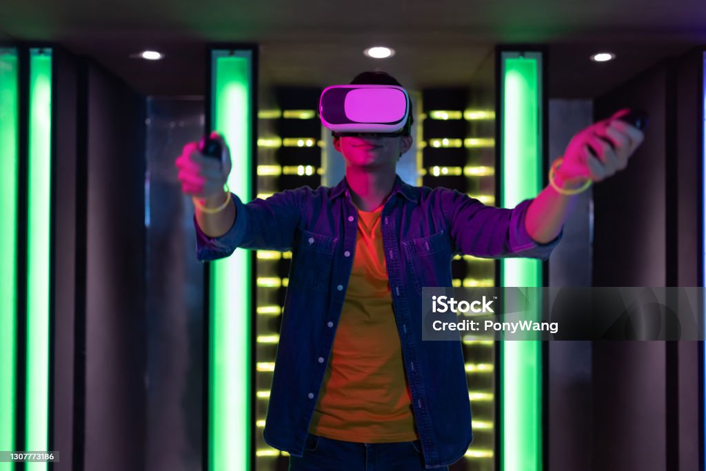 man win motion sensing game asian man plays motion sensing game and shake his arms with vr glasses Virtual Reality Stock Photo