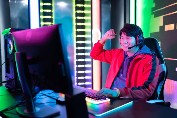 cyber sport gamer win game Young Asian Handsome Pro Gamer Win in Online Video Game with Fist Gesture games multiplayer online android stock pictures, royalty-free photos & images