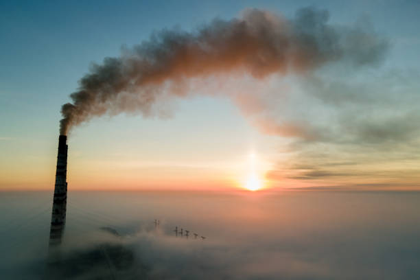 Aerial view of coal power plant high pipes with black smoke moving up polluting atmosphere at sunset. Aerial view of coal power plant high pipes with black smoke moving up polluting atmosphere at sunset. vapor trail photos stock pictures, royalty-free photos & images