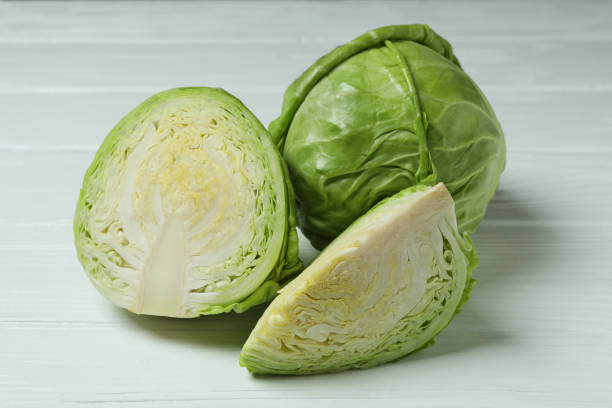 istock Fresh green cabbage on white wooden background 1307775784
