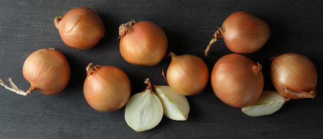 Garlic, onion and Spanish onion on a wooden plate, seasoning vegetables on a wooden kitchen table top, a top view with a copy space area