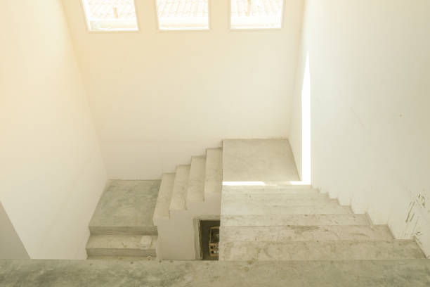 abstract stair concrete in new house structure use lightweight cement brick and white lintel plaster to joint for reinforce in site. three window with glass for sunlight.