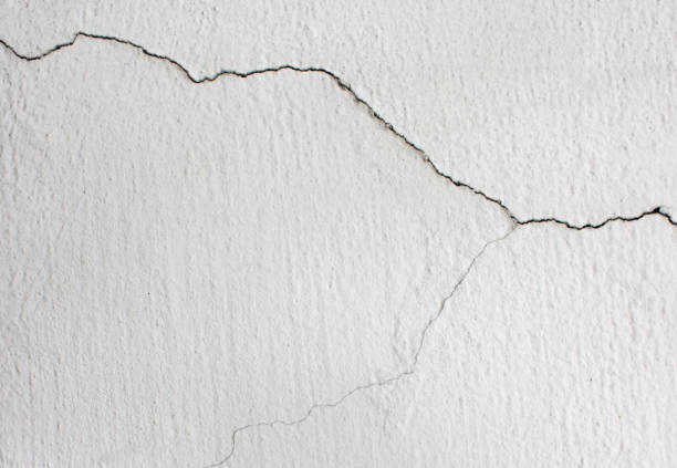 istock A crack in the white wall. Crack concrete wall texture background. 1307779421