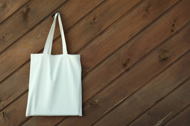 istock Blank eco bag on wooden background, space for text 1307779557