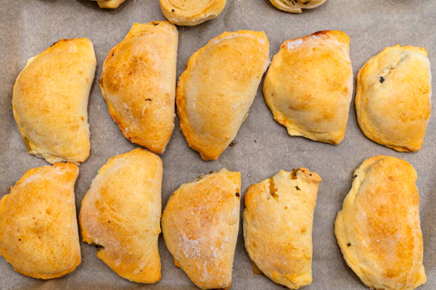 istock Frozen baked dumplings in dough on a baking sheet on baking paper, top view. 1307781112