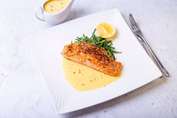 salmone con salsa ber blanc, spinaci e limone. decorato con porri. piatto tradizionale francese. - main course salmon meal course foto e immagini stock