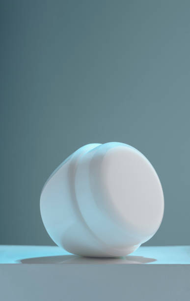 istock Vertical shot of Laying lotion cream container on white platform with copy space 1307782724