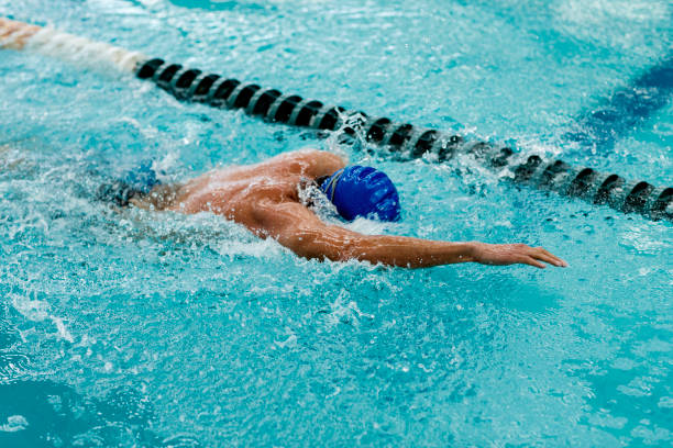 istock Young athletic man with butterfly swimming technique 1307783534