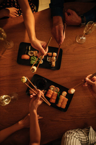 istock Close up of people eating sushi 1307785382