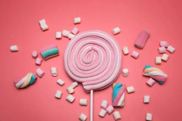 Photo of Marshmallows and lolly pop on the pink background.