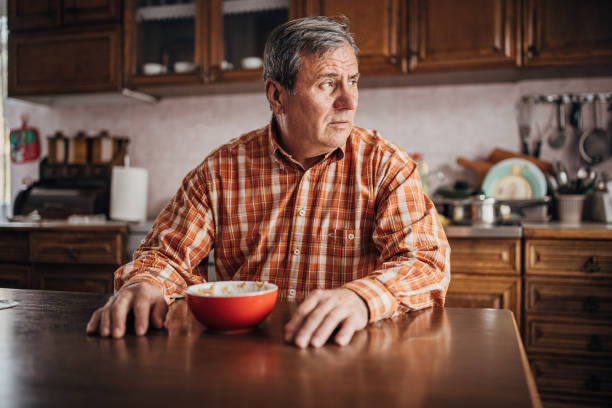 triste uomo anziano che mangia da solo - men senior adult serious depression foto e immagini stock