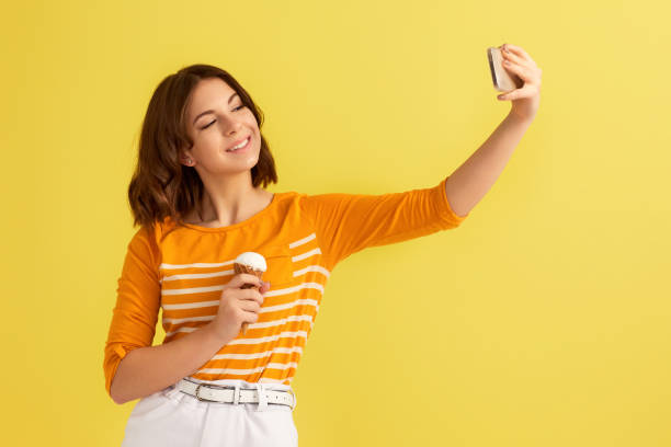 istock woman with vanilla ice cream making selfie 1307787082
