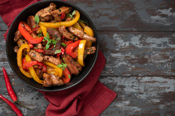 istock Spicy meat with peppers cooked in a wok 1307789166