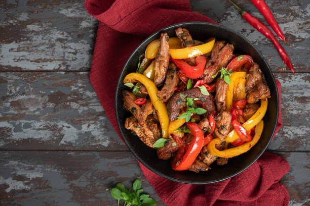 istock Spicy meat with peppers cooked in a wok 1307789176